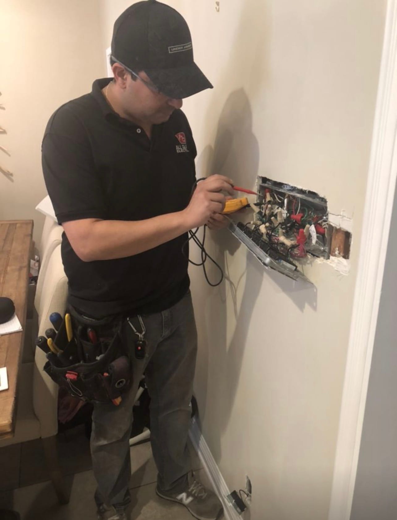 Technician testing a wall outlet with a multimeter