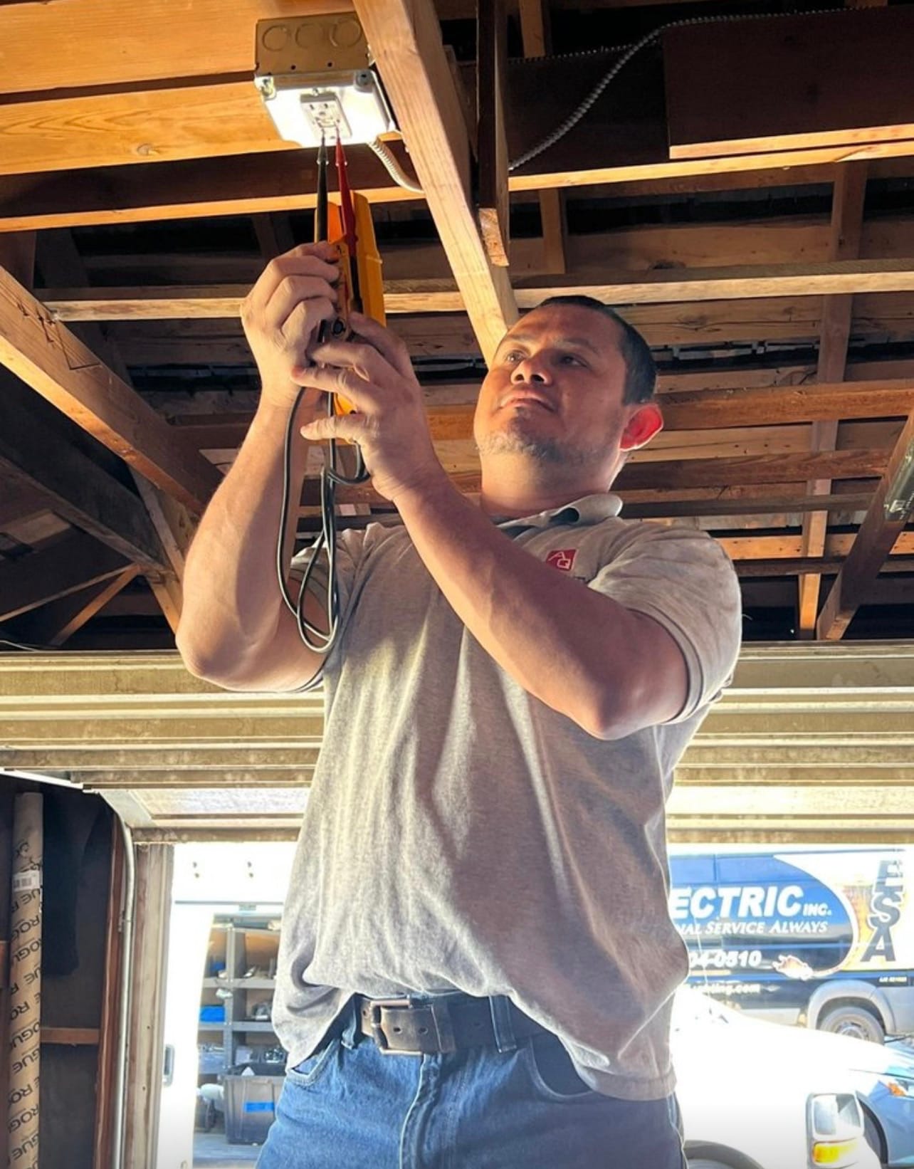 Technician troubleshooting a garage ceiling outlet