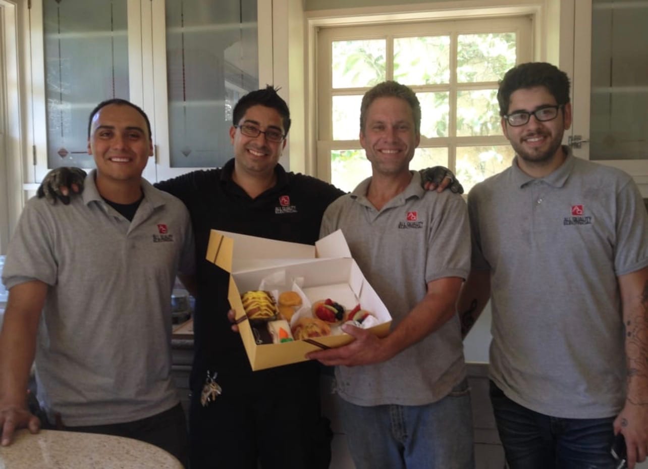 The AQE crew holding a box of donuts after a job